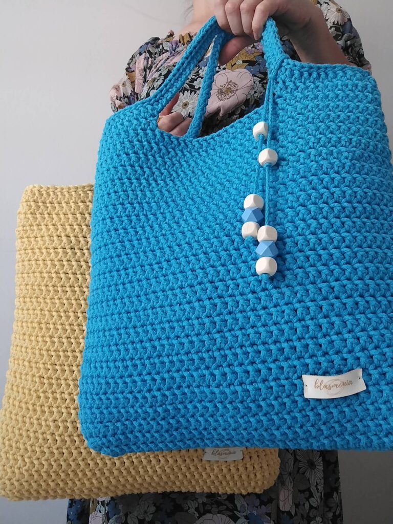 Bawełniana torba shopperka trzymana w ręce modelki