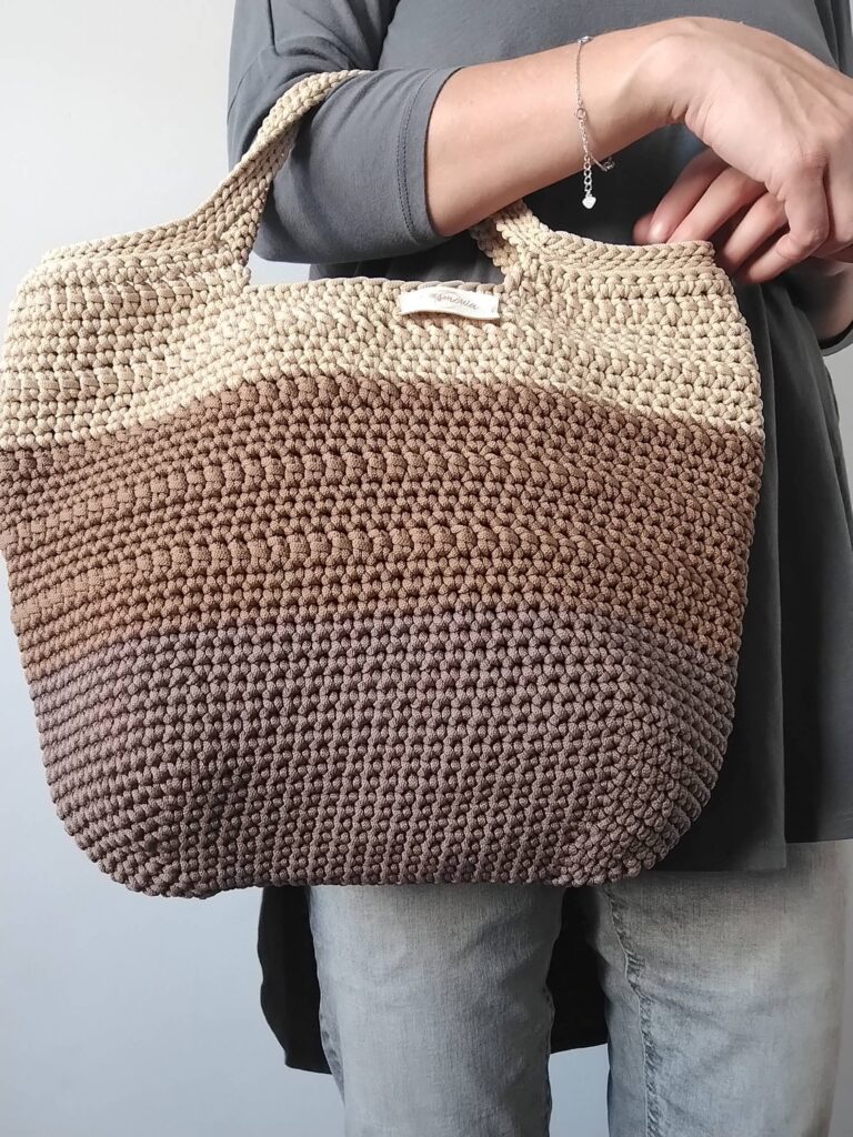 Torba shopperka w kolorze brązowym na ramieniu modelki